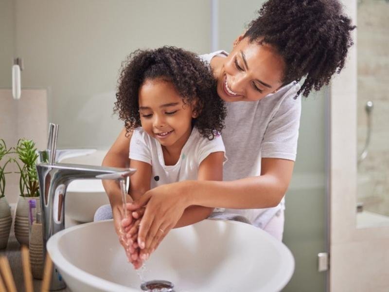 Mother and child washing hands together