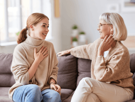 Mother and daughter speaking on couch
