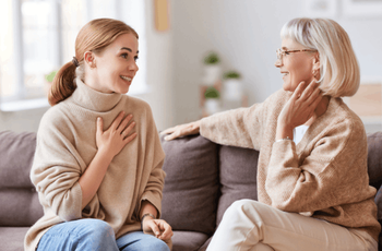 Mother and daughter speaking on couch