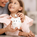 Young girl and her mother with a white piggybank