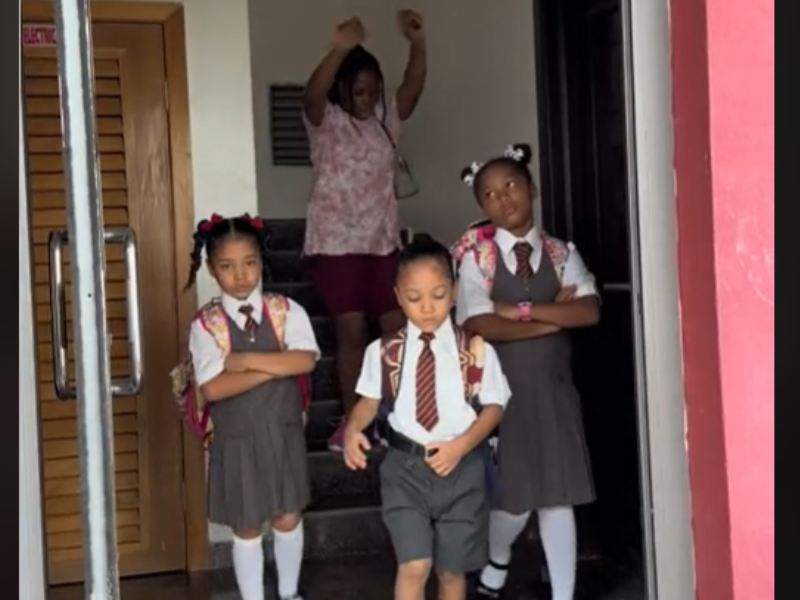 Mother dancing while her kids look grumpy in their school uniforms