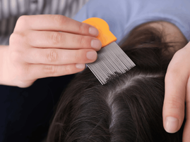 Mother using nit comb on her daughter's hair