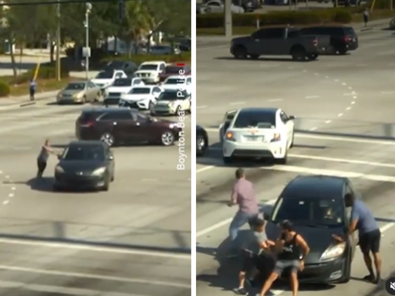 Motorists gather around a car to help driver