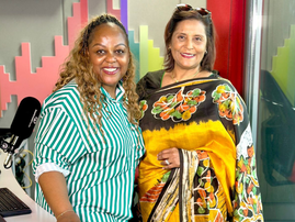 Carol Ofori standing with Veetha Sewkuran in East Coast Radio studios