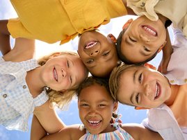 Multi Cultural Children Friends Linking Arms Looking Down Into Camera