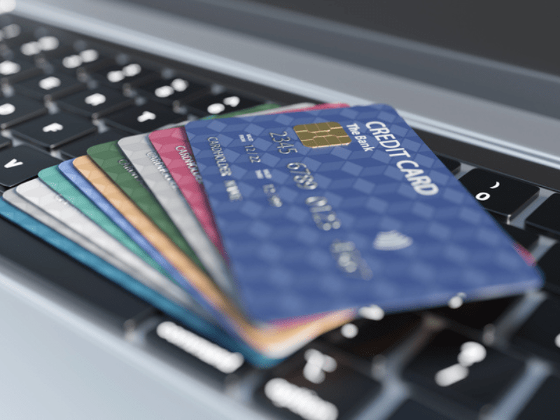 Multiple credit cards on a grey laptop