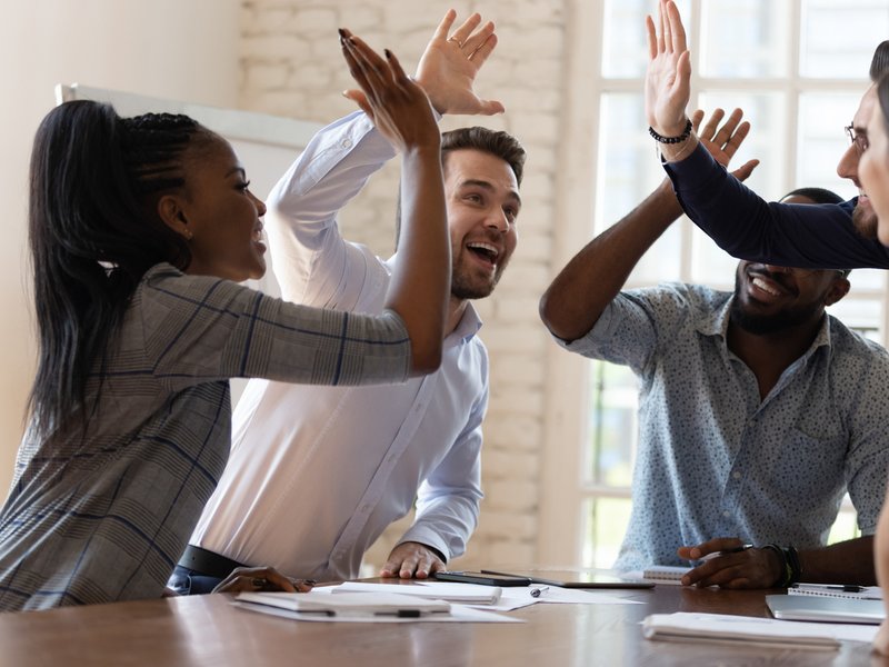 Multiracial euphoric business team people give high five in office iStock