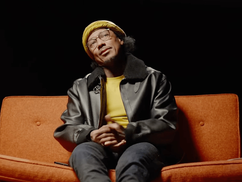 Nick Cannon sitting on an orange couch
