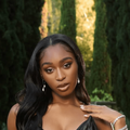 Normani poses outdoors in a black dress