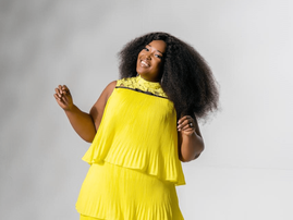 A cheerful Ntokozo Mbambo poses in a yellow dress