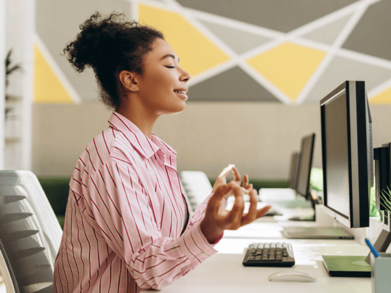 Office worker meditation at her desk for stress