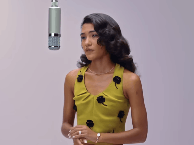 Olivia Dean standing in front of a vintage mic
