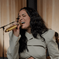 Kehlani holding a gold mic