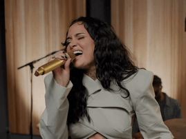 Kehlani holding a gold mic