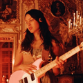 Olivia Rodrigo playing a pink guitar
