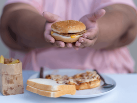 Overweight woman eating junk food