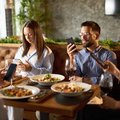 PEOPLE ON PHONES AT DINNER TABLE