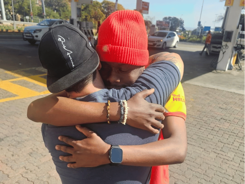 PETROL ATTENDANT AND MAN HUGGING