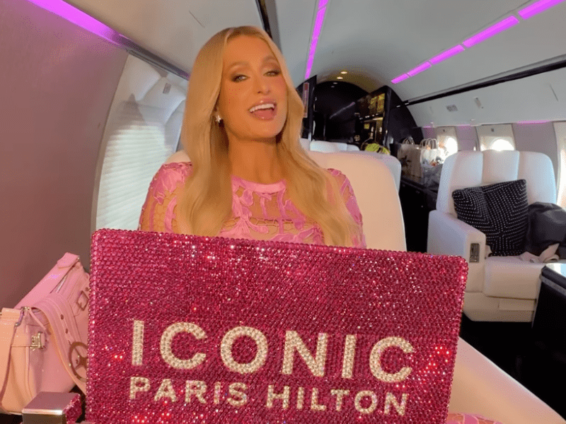 Paris Hilton sitting inside a private plane with a bedazzled laptop