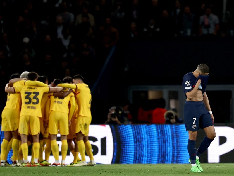 Paris Saint-Germain's French forward #07 Kylian Mbappe (R) reacts after Barcelona score