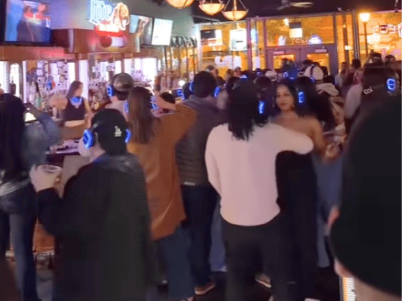 People dancing at a silent disco with headphones on