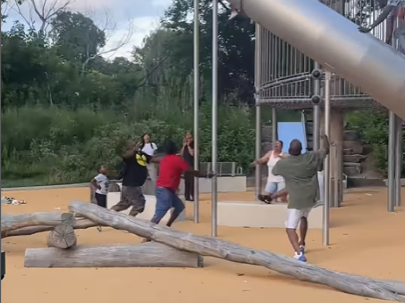 People run in a park as they see a child falling