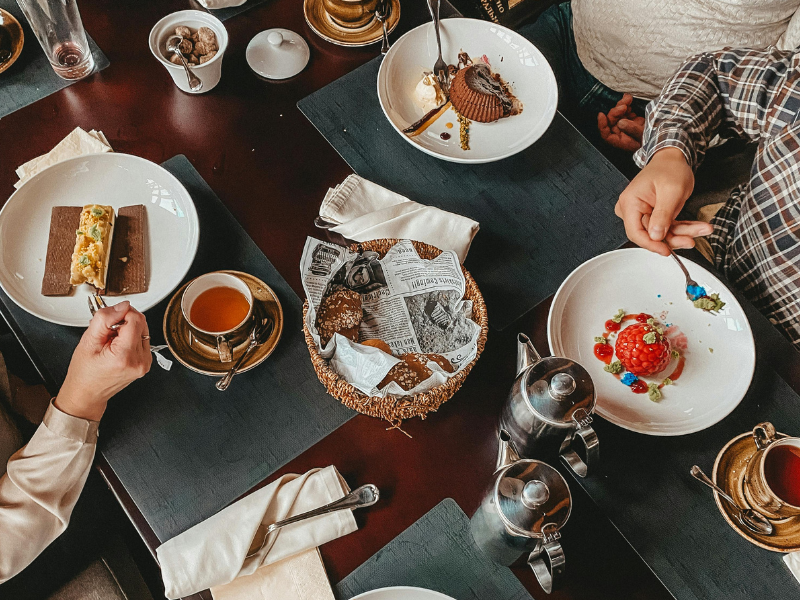 People seated at dining table eating desserts