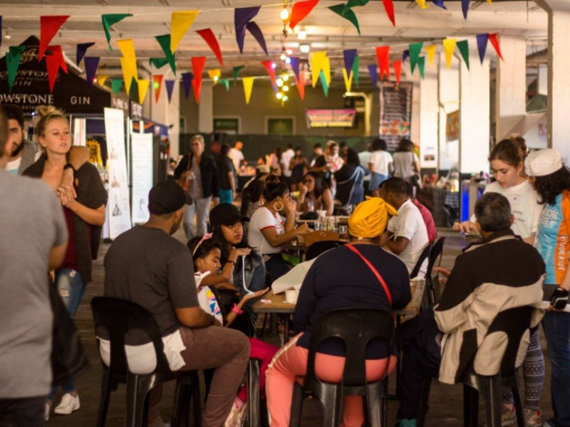 People seated at tables attending the Durban Street Food Festival