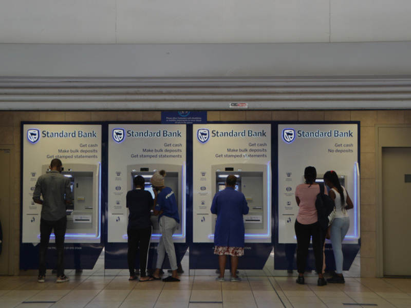People using Standard Bank ATMs in a public space