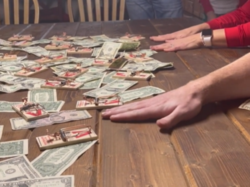 Peoples hands reaching out for money on a table