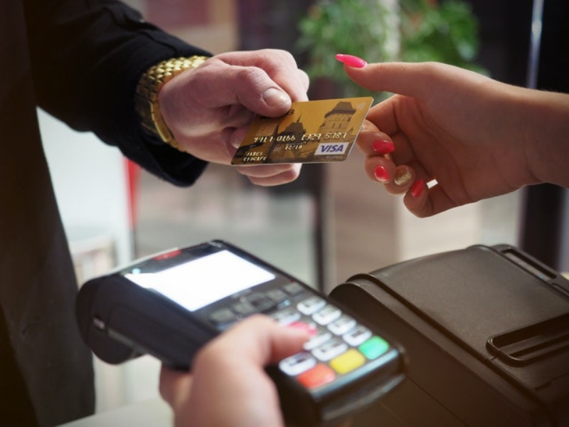 Person handing over bank card to pay for something