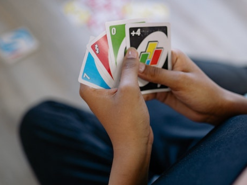 Playing American Card Game Uno, Holding Game Cards in Female Hand