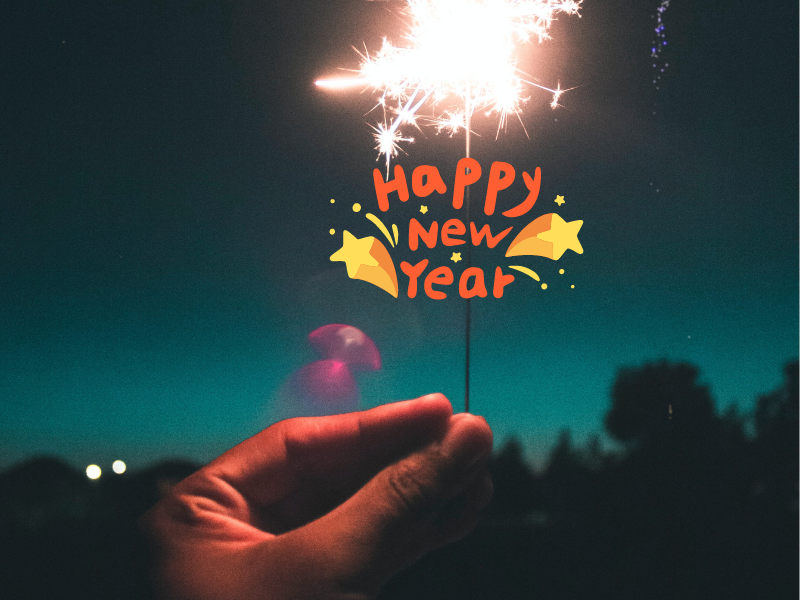 Person holding a sparkler with happy new year message
