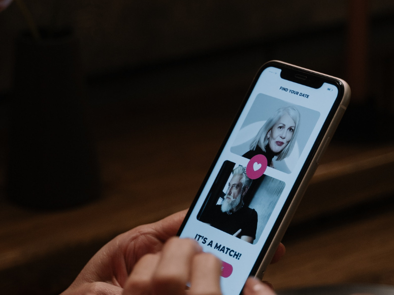 Person holding smartphone with dating app open