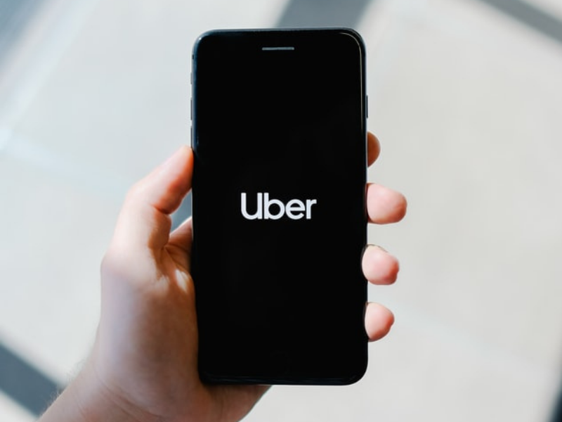 Person holding smartphone with Uber app open