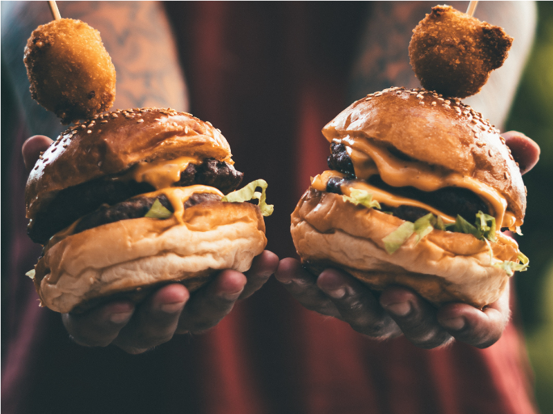 Person holding two hamburgers