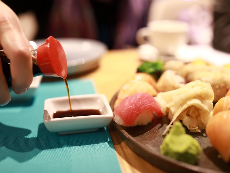Person pouring soy sauce
