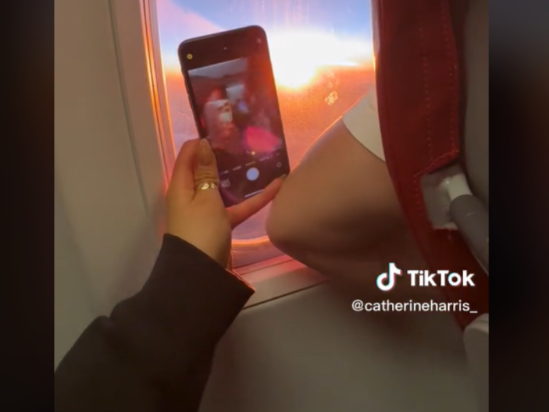 Person trying to take a pic of the sunset on a flight