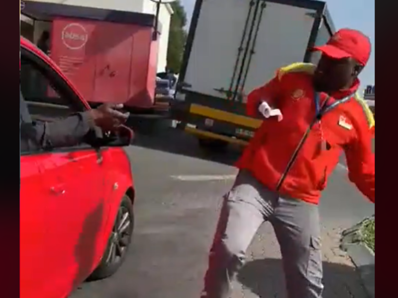 Petrol Attendant dancing next to a customer's car