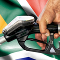 Petrol attendant fills up a tank with South African flag in the background