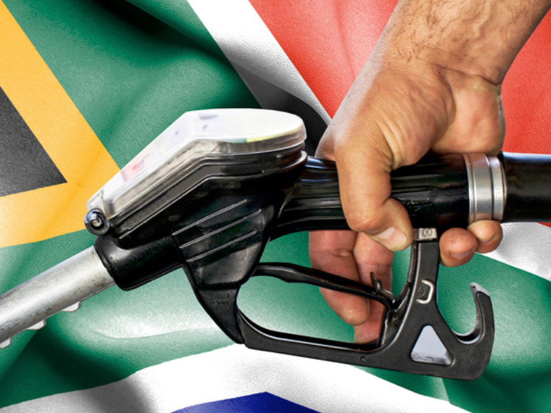 Petrol attendant fills up a tank with South African flag in the background