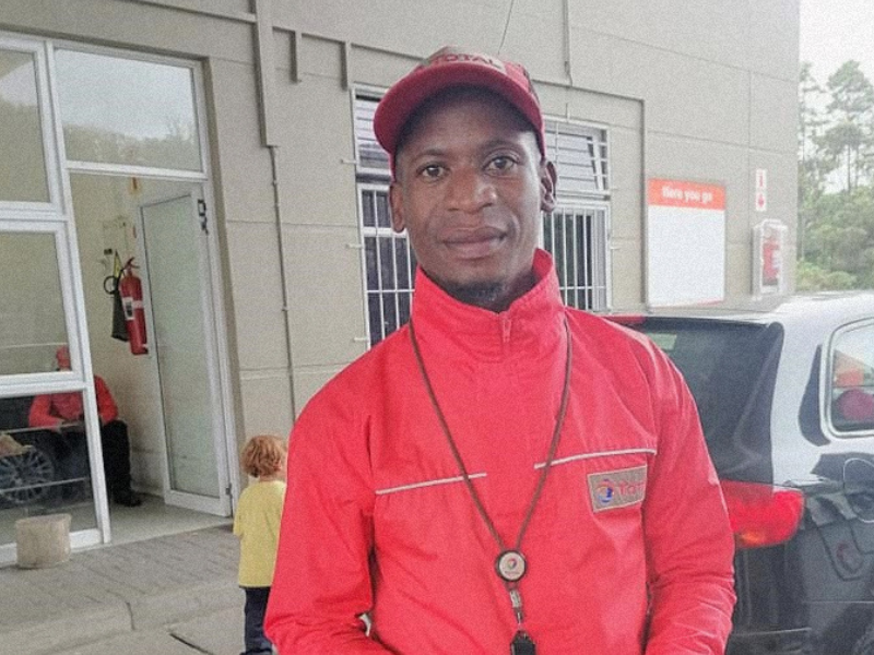 Petrol attendant standing at Shell garage