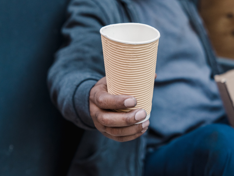 Photo of a beggar holding a paper cup