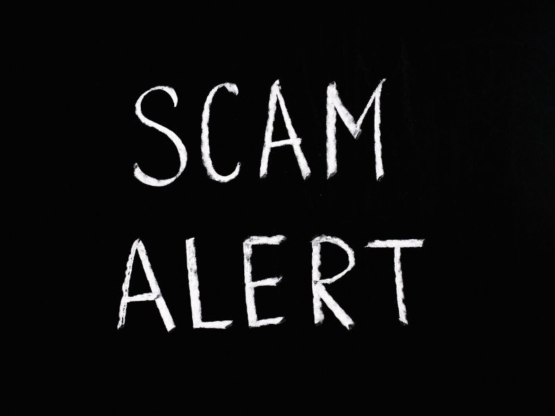 Photo of scam alert letting text on black background