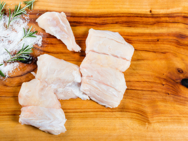 Piece of raw crocodile meat lying on a chopping board