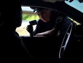 Police officer looking at driving licence card