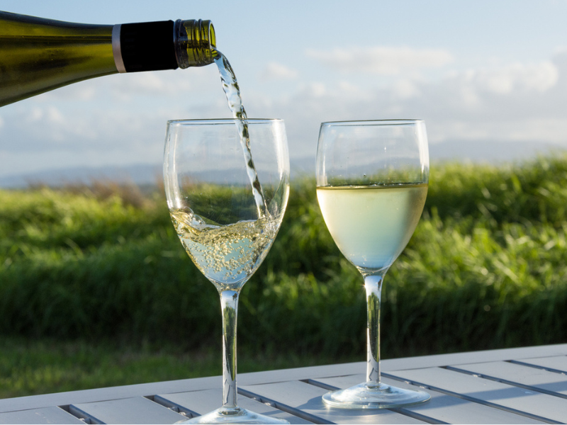 Pouring white wine into two glasses