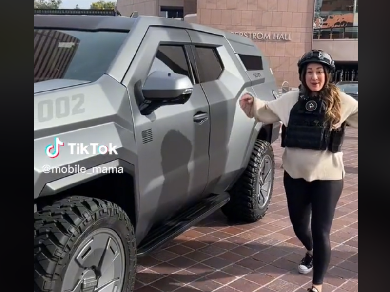 Pregnant woman standing next to armoured SUV