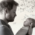 Prince Harry holds his daughter Lilibet in his hands