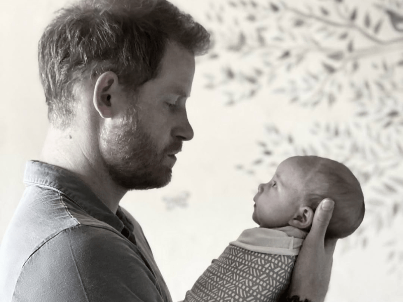 Prince Harry holds his daughter Lilibet in his hands